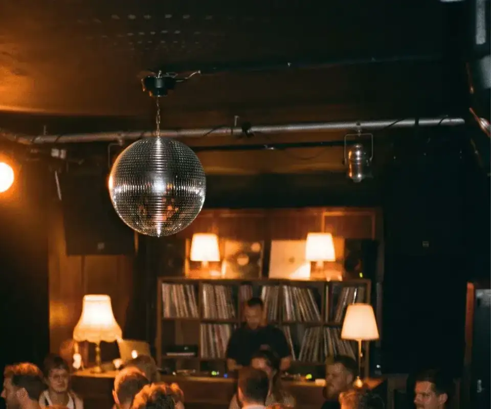 Discokugel und warme Lampen über der Bar