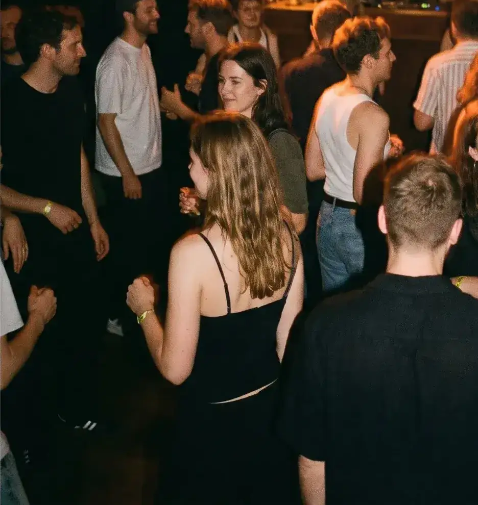 Gäste tanzen locker vor dem DJ-Pult